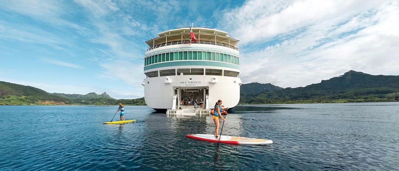 Gäste des Kreuzfahrtschiffes Le Paul Gauguin beim Stand-up-Paddling