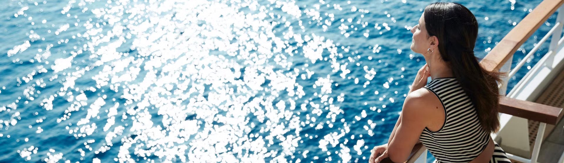 Frau genießt Ausblick von Terasse des Kreuzfahrtschiffes Seabourn Pursuit