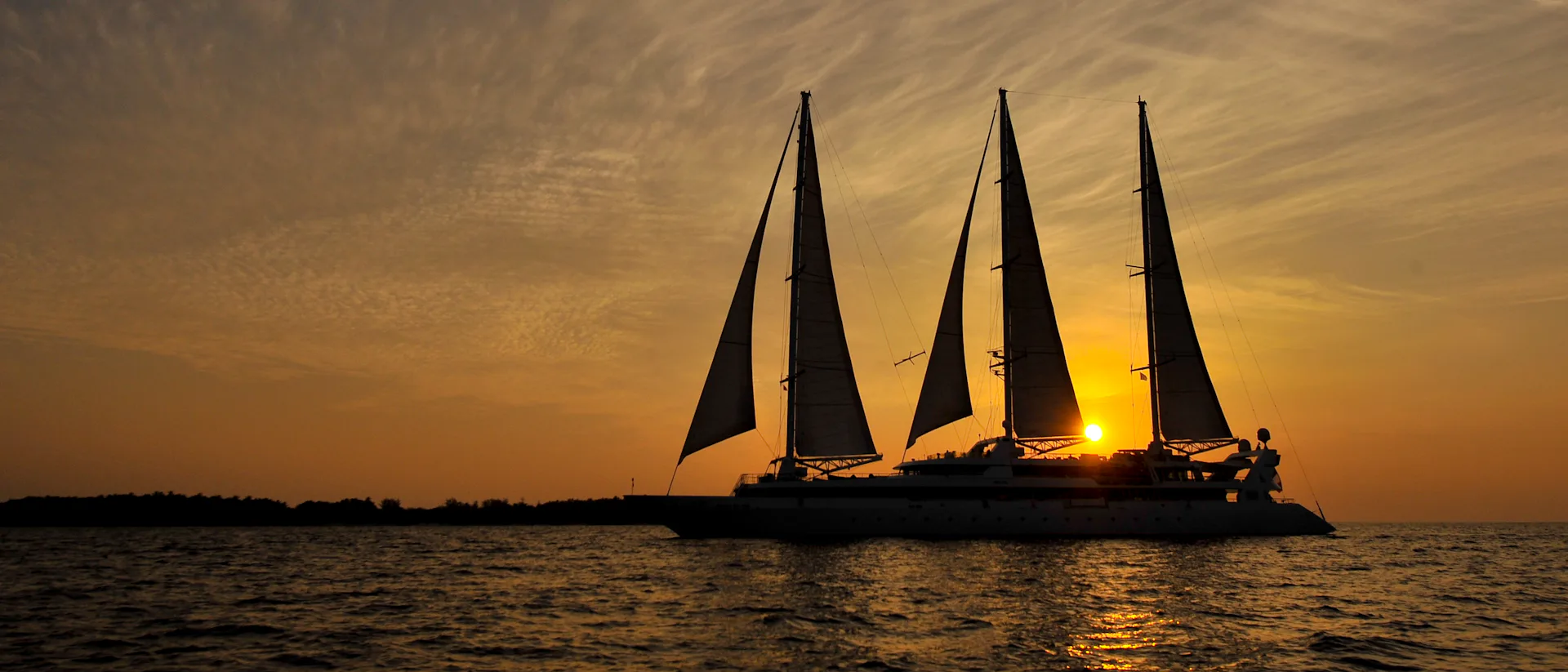 Kreuzfahrtschiff Le Ponant während der Fahrt im Sonnenuntergang
