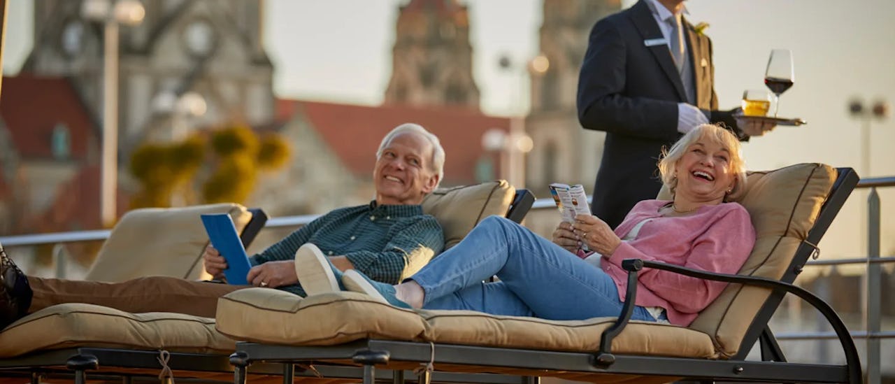 Gäste beim Entspannen auf der Terasse des Kreuzfahrtschiffes S.S. Joie de Vivre