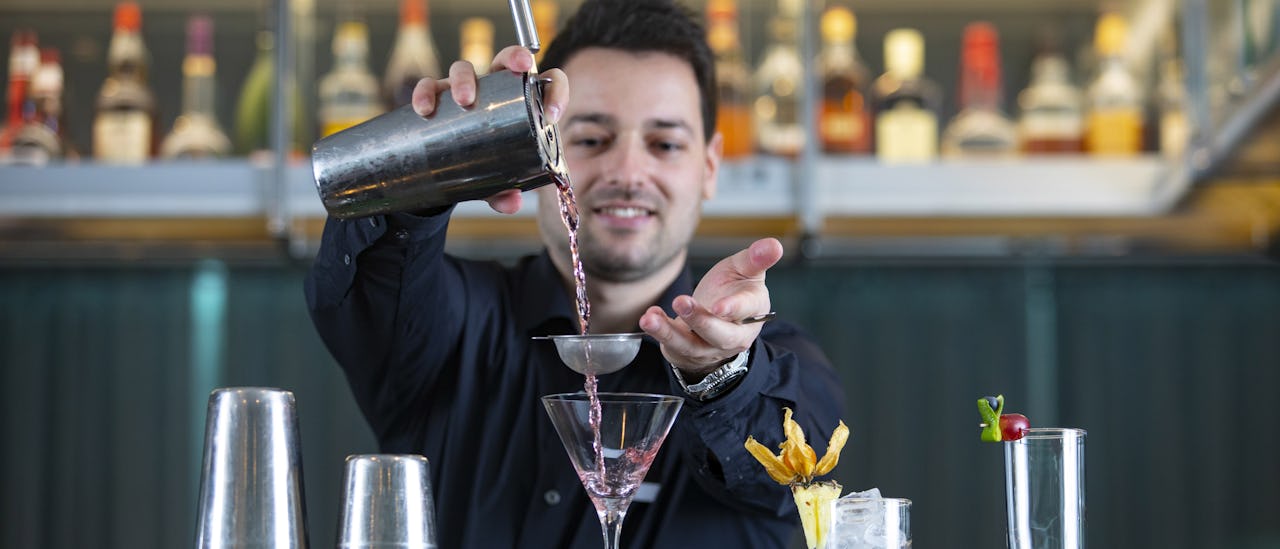Barkeeper des Kreuzfahrtschiffes Scenic Jasper beim Cocktail mixen